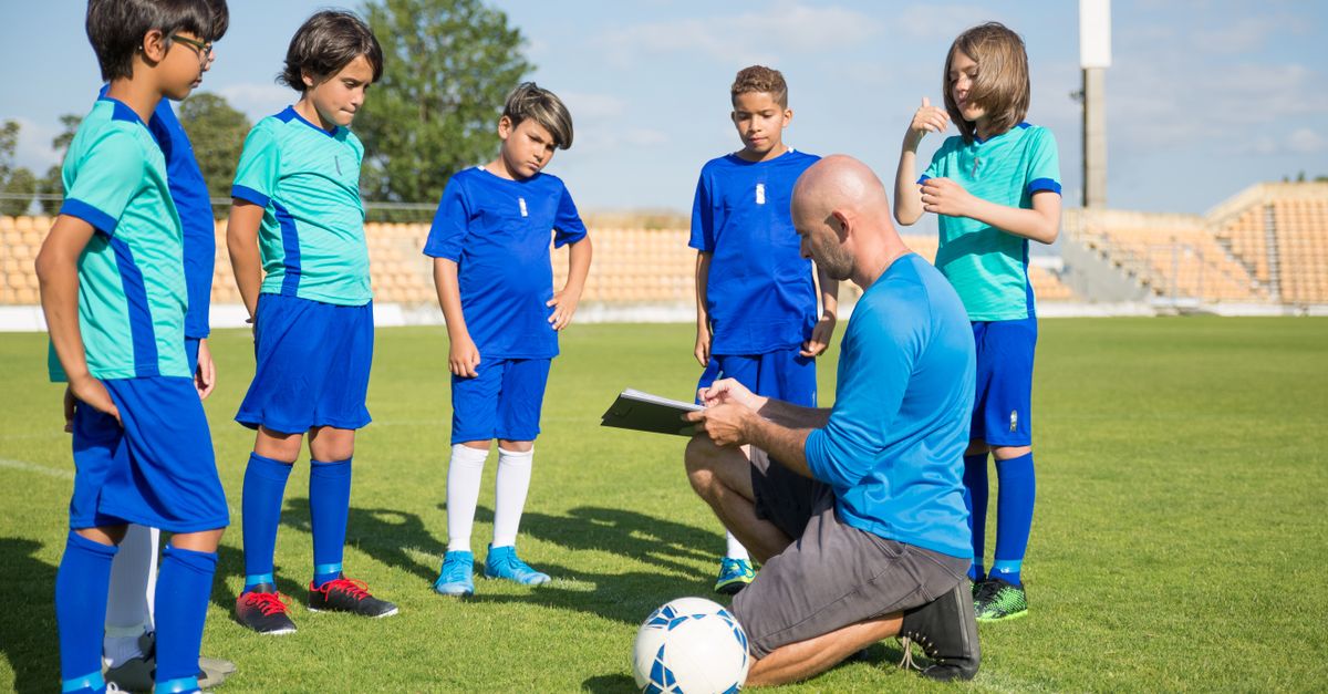 Coach instructing youth athletes